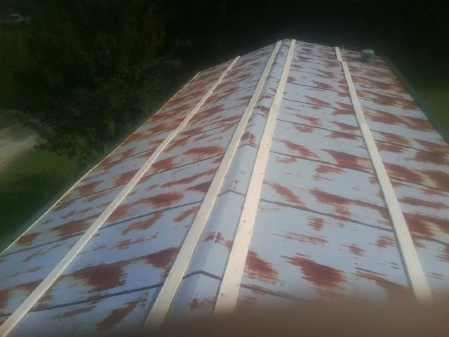 Rusted metal roof panels with new wood purlins before replacement — Storm Damage Roof Repair in Slayden by Roofing Brothers
