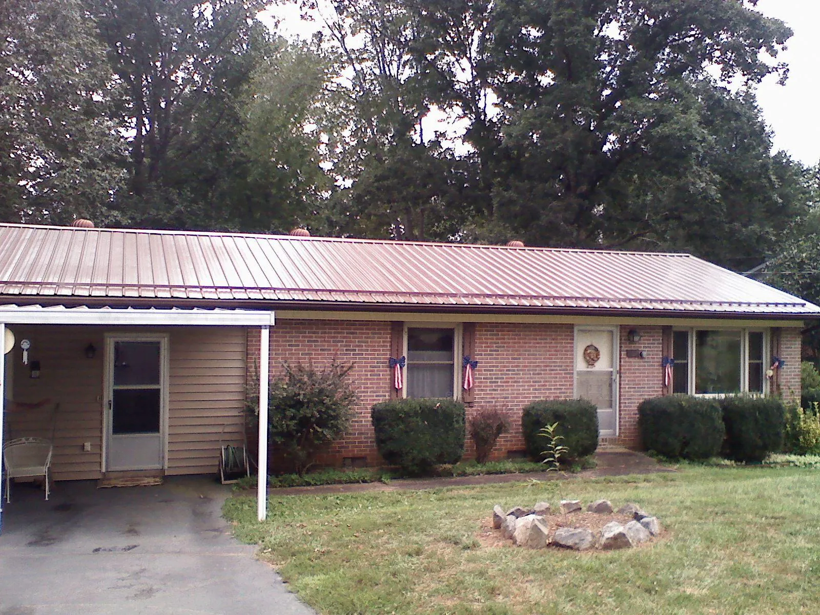 Bronze metal roof and carport on a brick ranch home — Roof Repair work by our crew in Slayden